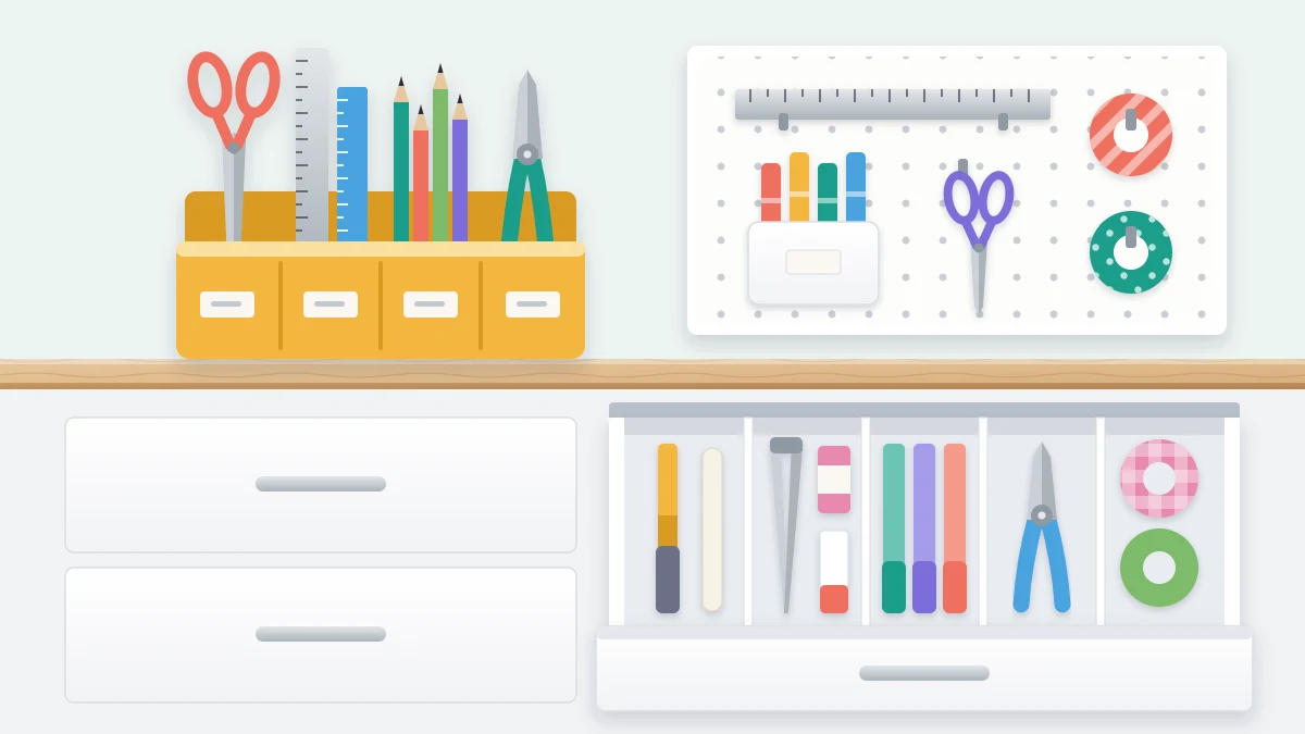 A desktop caddy with upright compartments holding scissors, rulers, pencils and pliers beside an open shallow drawer with dividers