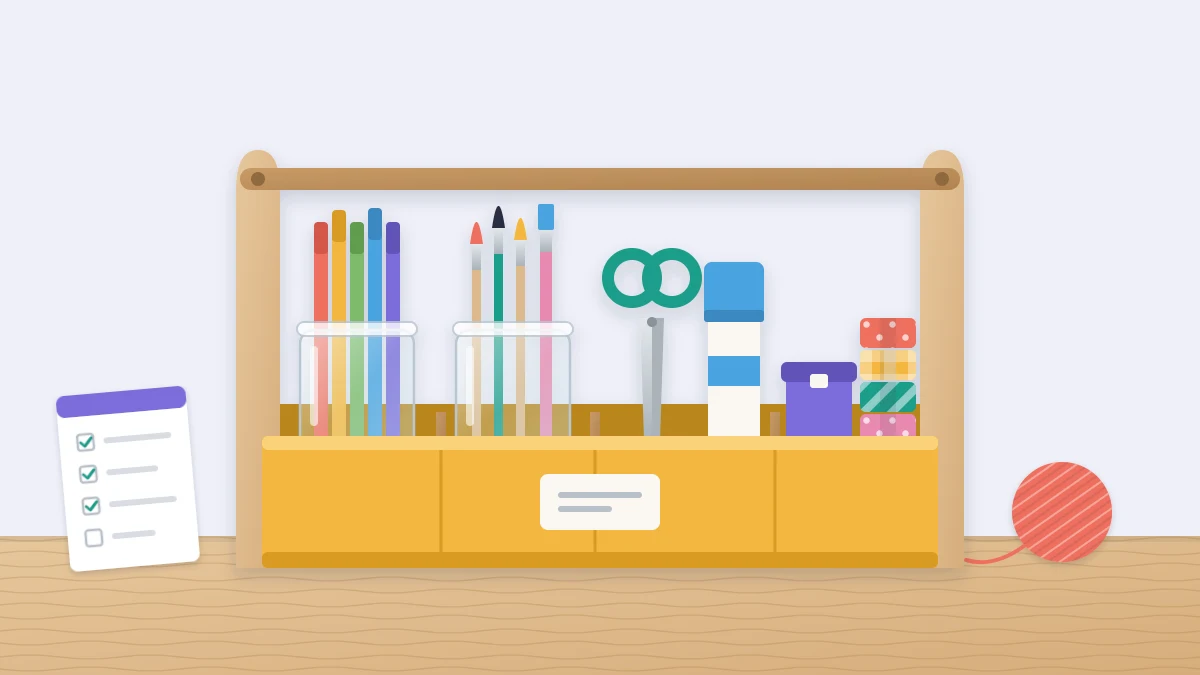 A handled caddy on a table with four compartments holding jars of pens and brushes, closed scissors, a glue stick, tape rolls and a small lidded box