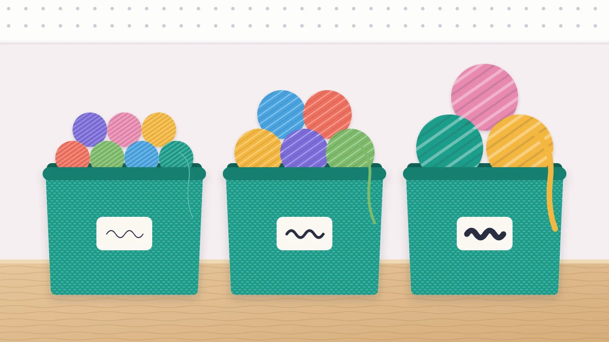 Three open bins on a table holding fine, medium and chunky yarn, each bin with several colors